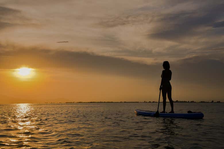 Viendo el atardecer desde una tabla de paddle surf